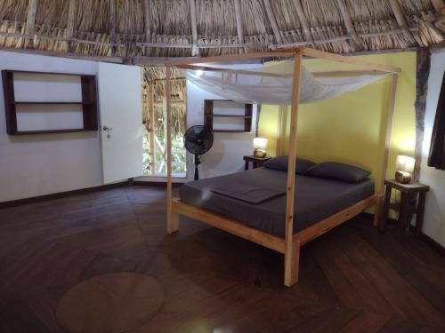 a bedroom with a bed with a canopy at Sexto Sentido Cabañas & Pan Frances in Palomino