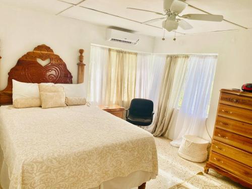 a bedroom with a bed and a ceiling fan at The Suite at Rhyne House book one or more bedroom in Montego Bay