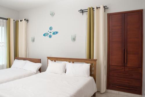 two beds sitting next to each other in a bedroom at The Pearl Cottages in Kampala