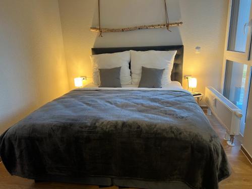 a bedroom with a large bed with two lamps at Charming Homes - Studio 25 in Wolfsburg