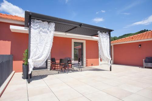 a patio with awning and a table and chairs at Quinta da Pitarrela in Peso da Régua