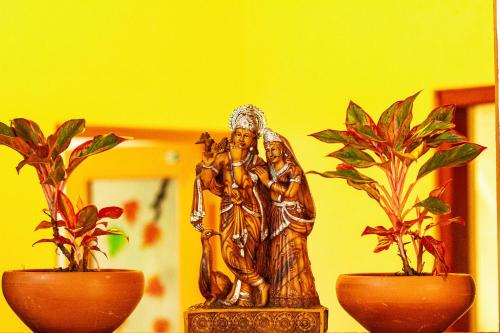 a statue of two people and two potted plants at Golden Town Hotel in Tangalle