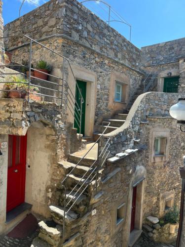 a stone building with stairs and a red door at Spacious 2 bedroom condo in Colletta