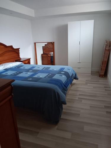 Schlafzimmer mit einem Bett mit blauer Decke in der Unterkunft Apartamento Triana in Alovera