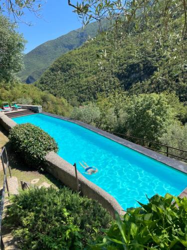 a person swimming in a pool with mountains in the background at Spacious 2 bedroom condo in Colletta