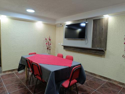 Sala de conferencias con mesa y TV de pantalla plana en Hostal Ollague, habitaciones con baño privado, en Calama