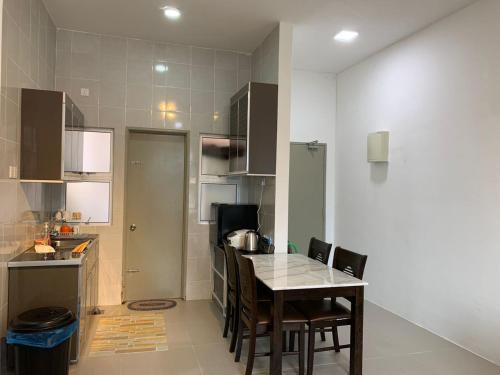 - une cuisine avec une table et des chaises dans la chambre dans l'établissement Alliv NSF Studio & 1 Bedroom Apartment Stay, à Brinchang