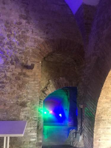 een tunnel in een kasteel met blauw en groen licht bij Cantina della musica per eventi in San Polo