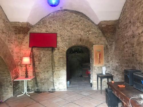 una habitación con una pared de ladrillo y una caja roja en la pared en Cantina della musica per eventi en San Polo
