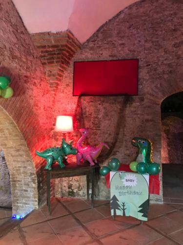 una habitación con estatuillas de dinosaurio en una mesa con una pared roja en Cantina della musica per eventi en San Polo