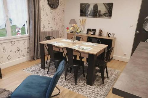 una sala da pranzo con tavolo e sedie in legno di Maison de ville 70m² a Champagnole