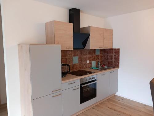 a kitchen with white cabinets and a white refrigerator at Feriennest Ossiachersee in Bodensdorf