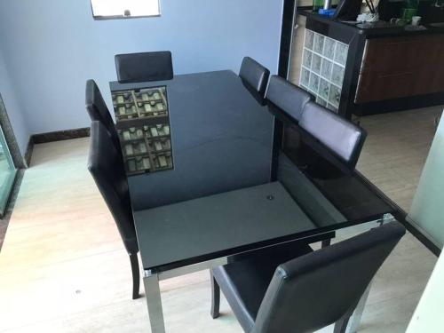 a black dining room table with black chairs at Casa confortável p/13/14/18 pessoas c 4/5/6 suítes in Belo Horizonte