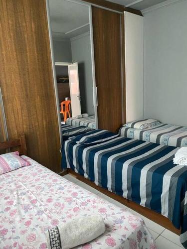 a room with three beds and a mirror at Casa confortável p/13/14/18 pessoas c 4/5/6 suítes in Belo Horizonte