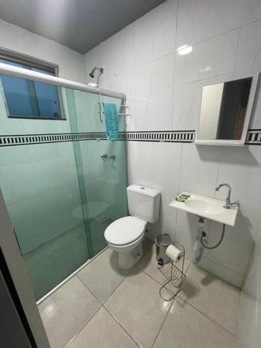 a bathroom with a toilet and a shower and a sink at Casa confortável p/13/14/18 pessoas c 4/5/6 suítes in Belo Horizonte