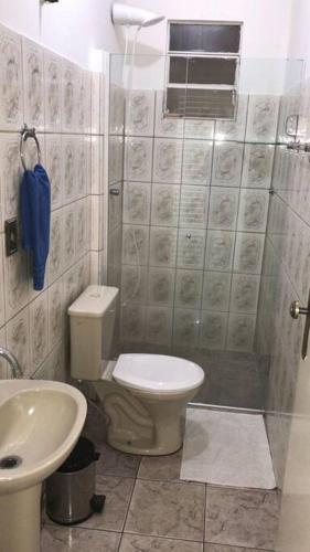 a bathroom with a toilet and a sink and a shower at Casa confortável p/13/14/18 pessoas c 4/5/6 suítes in Belo Horizonte