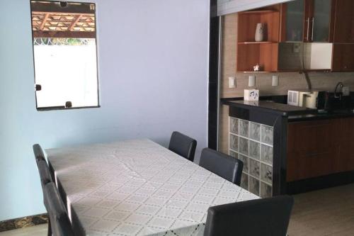 a dining room with a table and chairs and a kitchen at Casa confortável p/13/14/18 pessoas c 4/5/6 suítes in Belo Horizonte