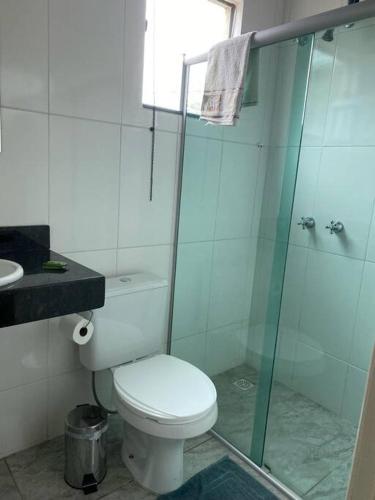 a bathroom with a toilet and a glass shower at Casa confortável p/13/14/18 pessoas c 4/5/6 suítes in Belo Horizonte