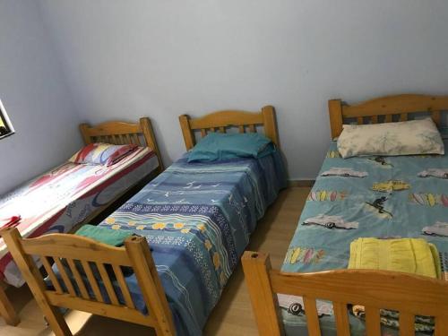 two beds sitting next to each other in a room at Casa confortável p/13/14/18 pessoas c 4/5/6 suítes in Belo Horizonte