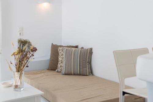 a couch in a living room with a vase of flowers at Soulmate's Suites Tinos in Kionia