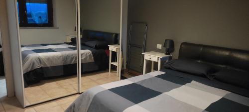 ein Hotelzimmer mit 2 Betten und einem Spiegel in der Unterkunft MI CASA ES TU CASA in San Paolo