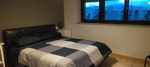 Schlafzimmer mit einem schwarzen und weißen Bett und einem Fenster in der Unterkunft MI CASA ES TU CASA in San Paolo