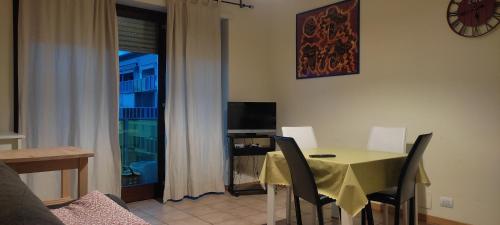 MI CASA ES TU CASA في San Paolo: غرفة طعام مع طاولة وكراسي ونافذة