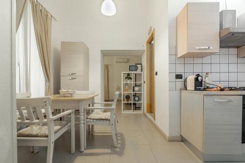 a kitchen with a table and chairs in a room at Zefnea House in Catania