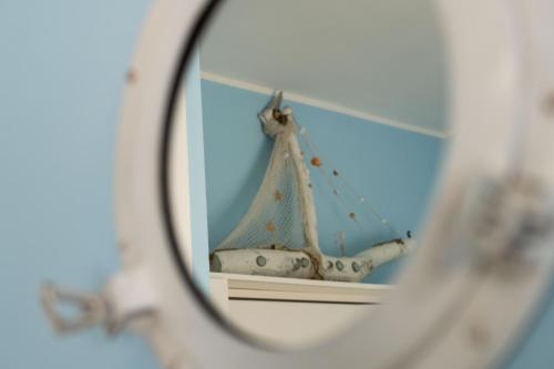 a mirror with a reflection of a boat in it at The Sorabellas in Gaeta