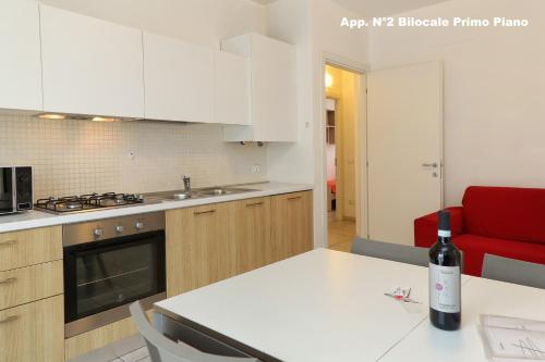 a kitchen with a bottle of wine sitting on a table at 3V Apartments Bardolino in Bardolino