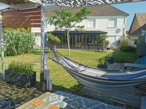 a hammock in the yard of a house at Chambre 25m2 petit déjeuner en option in Roézé-sur-Sarthe