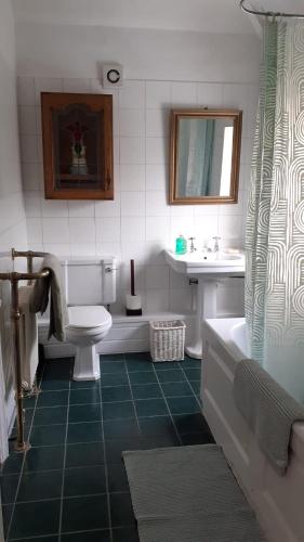 a bathroom with a tub and a toilet and a sink at Kingsway Bed & Breakfast in Broxbourne