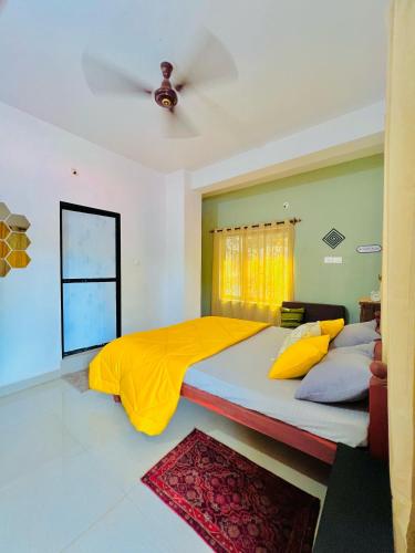a bedroom with a large bed with a ceiling fan at Mitra Homes Mandrem in Mandrem