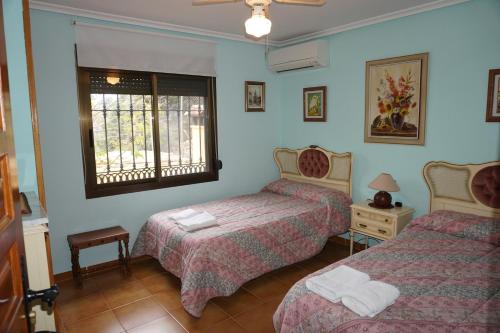 a hotel room with two beds and a window at Casa Rural Noel en Parque Natural Lagunas de Ruidera in Ossa de Montiel