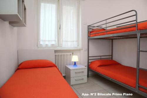 バルドリーノにある3V apartments Bardolinoのベッドルーム1室(二段ベッド2組、ランプ付)