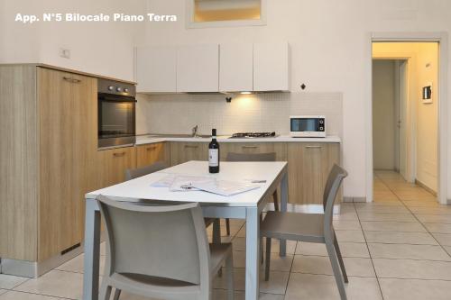 a kitchen with a table with a bottle of wine on it at 3V Apartments Bardolino in Bardolino