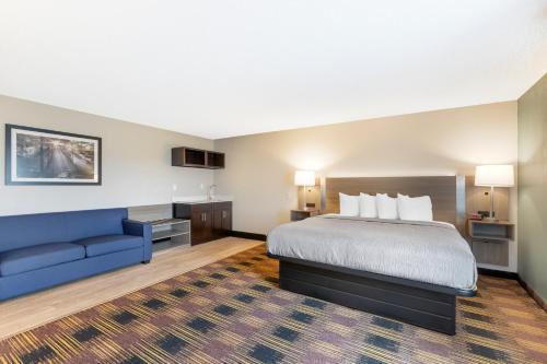 a hotel room with a bed and a blue couch at Quality Inn Newton at I-80 in Newton