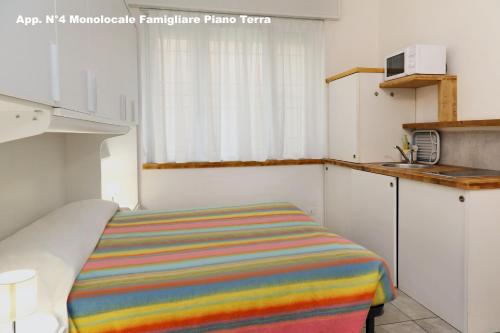 a small kitchen with a striped bed in a room at 3V Apartments Bardolino in Bardolino