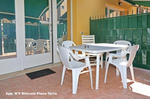 a white table and chairs on a patio at 3V Apartments Bardolino in Bardolino