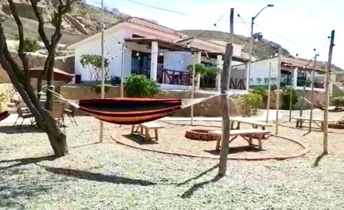 a hammock in a yard in front of a house at Casuarinas Del Mar Chalet de 2 habitaciones in Canoas De Punta Sal