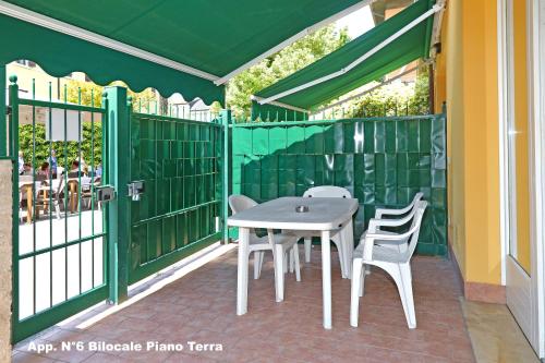 a table and chairs on a balcony with a green fence at 3V Apartments Bardolino in Bardolino
