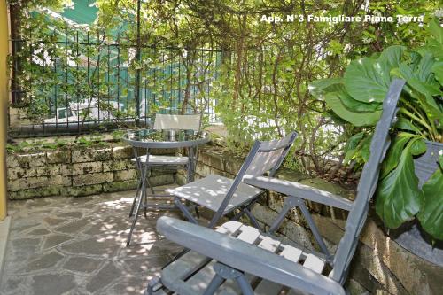 two chairs and a table in a patio with a fence at 3V Apartments Bardolino in Bardolino