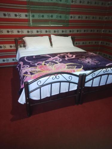 1 cama en una habitación con pared en Moon city camp, en Wadi Rum