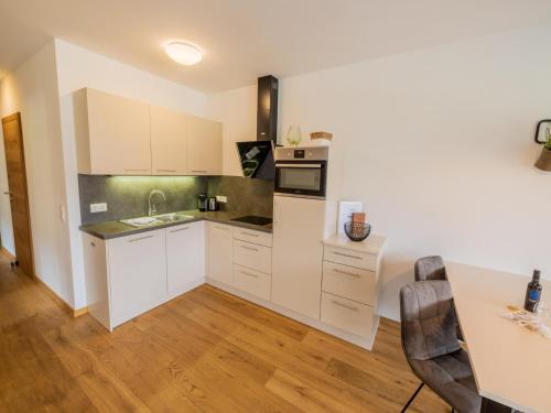 a kitchen with white cabinets and a wooden floor at Kreischberg The Exclusive 6 in Sankt Lorenzen ob Murau
