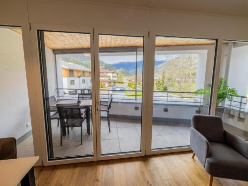 a living room with sliding glass doors with a table and chairs at Kreischberg The Exclusive 6 in Sankt Lorenzen ob Murau