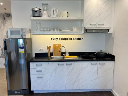 a kitchen with a stainless steel refrigerator and a sink at La Mirada Residences Sea-view Suites in Mactan