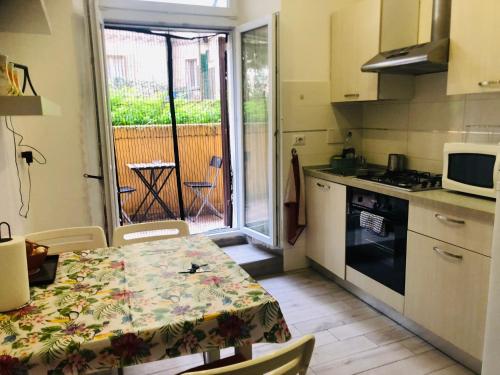 a kitchen with a table and a kitchen with a view of a balcony at Colibrì Apartment in Rome