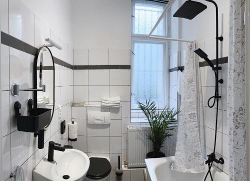 uma casa de banho branca com um lavatório e um chuveiro em Serviced Room im Herzen Berlin‘s em Berlim