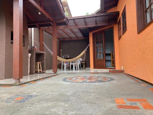 a patio with a hammock in the middle of a building at Residencial Casa Laranja - Casas na Praia da Ferrugem in Garopaba
