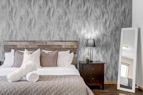 a bedroom with a large bed and a mirror at Coral Springs Lakefront Retreat in Calgary